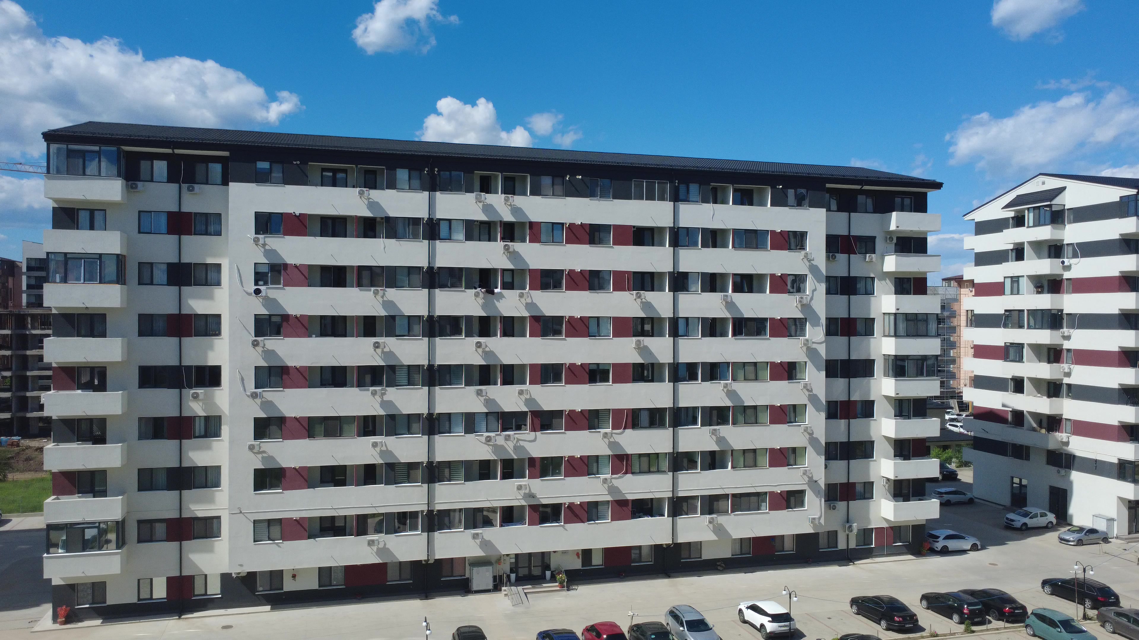 Vedere aeriană frontală a clădirilor Avangarde finalizate, cu parcarea amenajată
